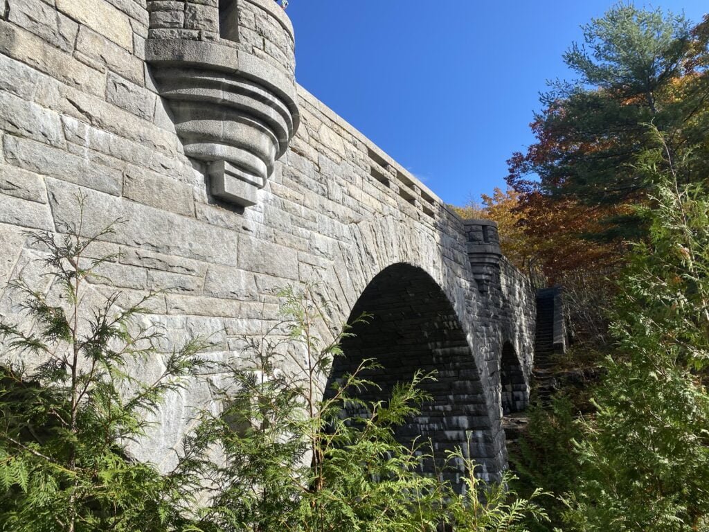 John Rockefeller Jr, contributed so much to the development of Acadia National Park. Especially important to the park we enjoy today, are the numerous granite-faced carriage road bridges that fit so well with their natural surrounding. This photo shows a light colored granite tri arch bridge that carries the carriage road over noisy duck brook as it cascades over the rocks below. This bridge feels part castle, part work of art. The setting is lovely. There is an amazing variety of trees in this part of the forest. The fall colors here are magnificent for their variety and vibrance.